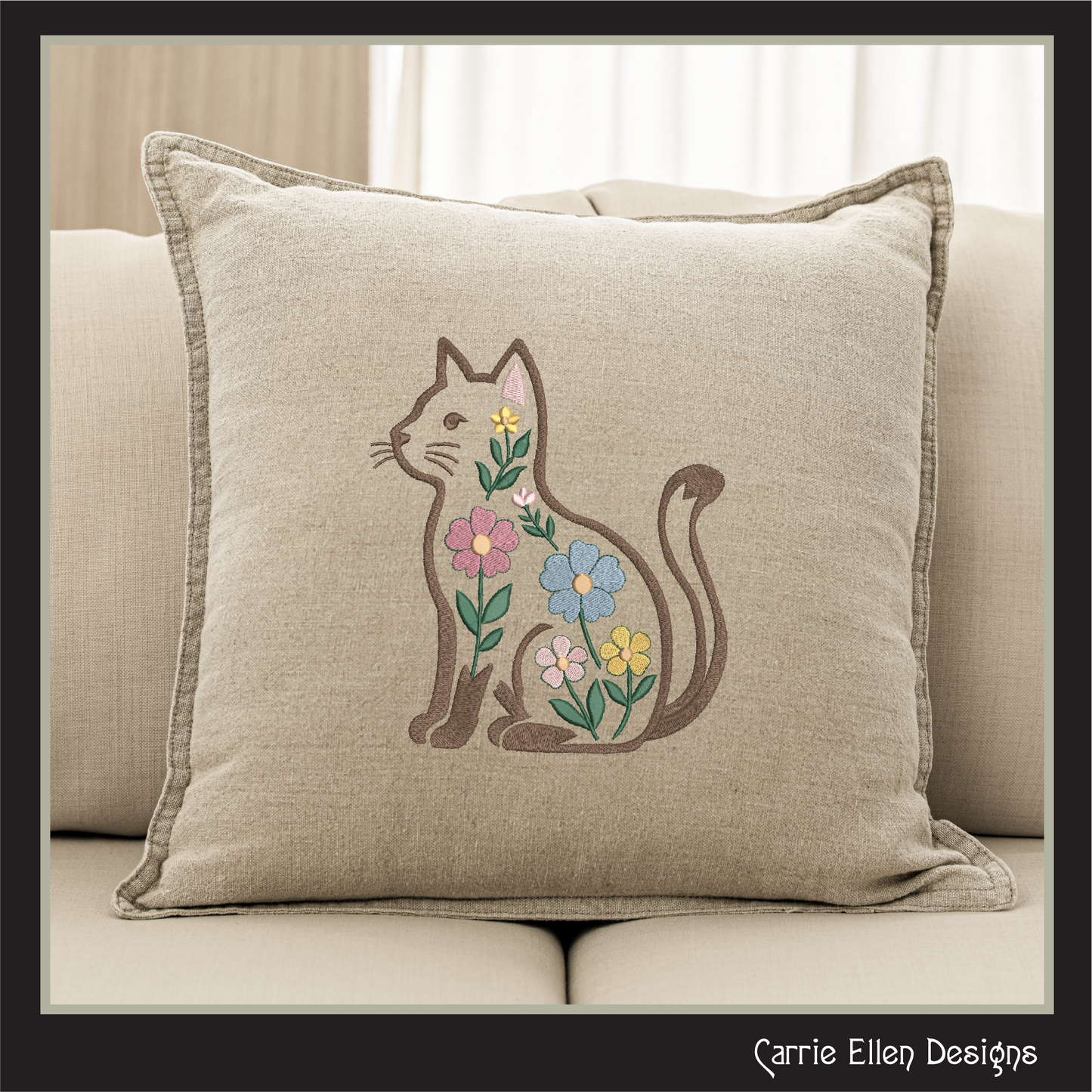 Decorative pillow with embroidered cat and flowers on a beige couch.