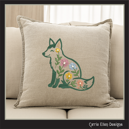 Decorative pillow with embroidered fox and flowers on a beige couch.